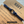 Navy paracord bracelet on a brown card with text