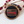 Wooden ornament with American flag design and engraved text on a white background with red berries.