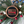 Decorative ornament with American flag and axe symbol, surrounded by greenery and berries.