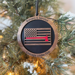 Decorative ornament with American flag and axe symbol, text 'Bravery & Service, Courage Under Fire' on a Christmas tree.