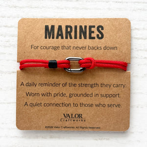 Red bracelet on a brown card with 'MARINES' text and Valor Craftworks branding.