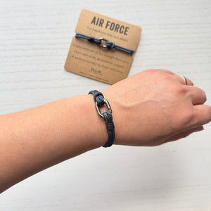 Bracelet on wrist with 'Air Force' card in the background