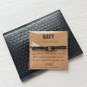 Navy-themed bracelet with packaging on a textured surface
