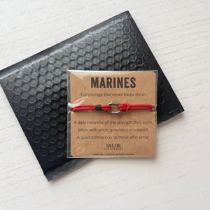 Red bracelet with a card labeled 'Marines' on bubble mailer