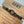 Bracelet with a knot design on a brown card with 'ARMY' text