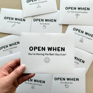 Set of 'Open When' cards with various scenarios and a hand holding one card.