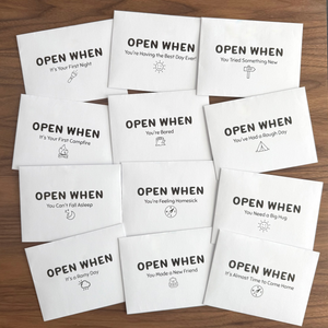 Set of 'Open When' cards on a wooden surface