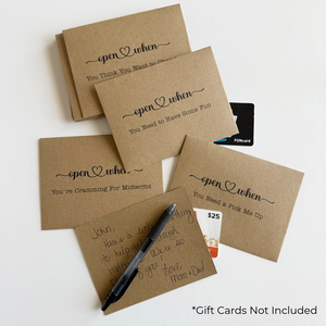 Set of brown paper cards with humorous text, gift cards and pen on a white background