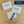 Two white envelopes and one card with 'Open When' text on a wooden surface, accompanied by a pen.