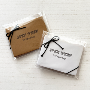 Two packages with 'Open When It's Game Day!' text on a white background
