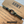 Green paracord bracelet with metal clasp on a brown card with text