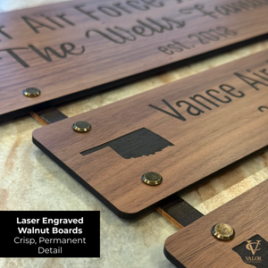 Close-up of engraved walnut duty station boards with custom Air Force locations and years