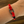 Red rope bracelet with a metal clasp on a wrist against a wooden background