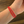 Red bracelet on a wrist with a wooden surface background