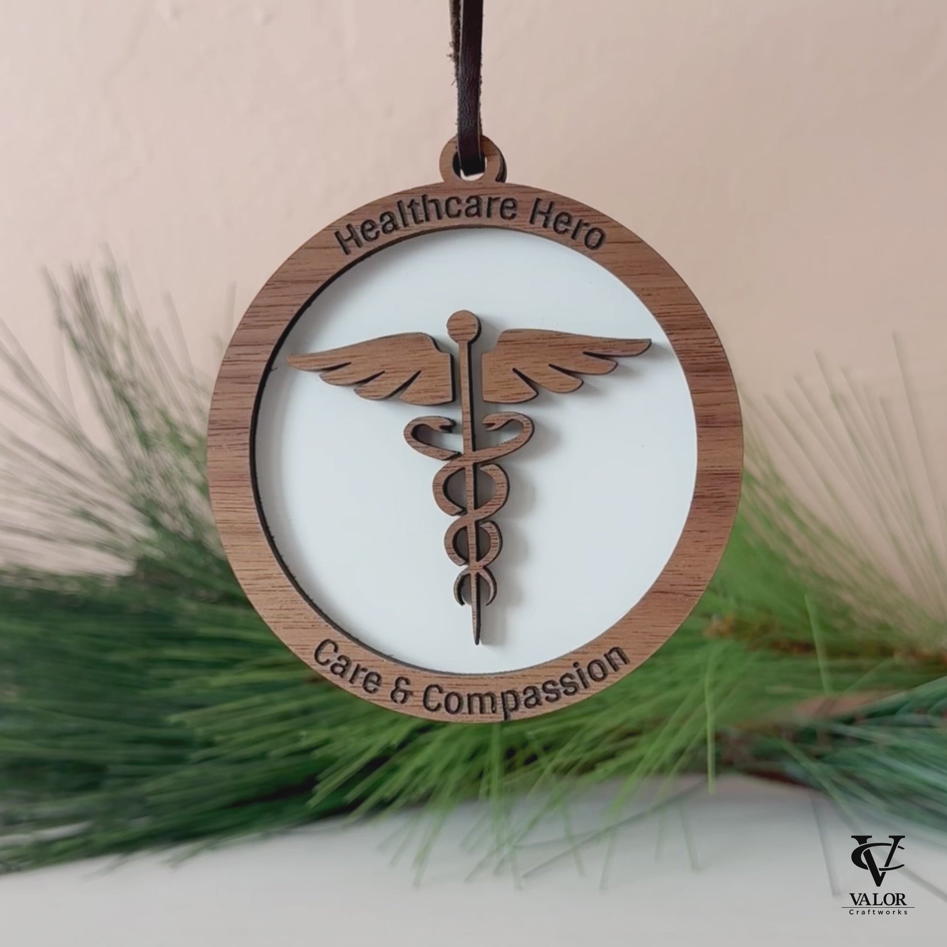 Video showing Healthcare Hero ornament on display with greenery in background